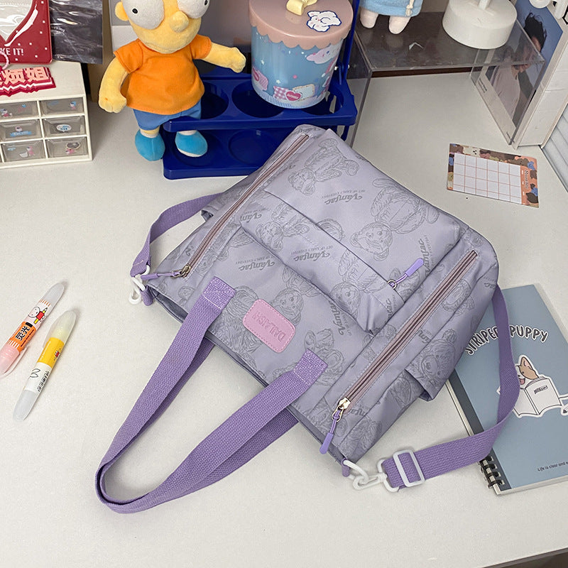 Close-up of the bear charm detail and multi-pocket exterior on the Everyday Bear tote